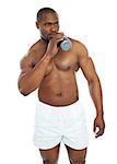 Muscular male drinking health drink and looking away