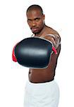 Muscular black boxer punching right into camera. Feel the heat.