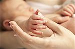 Closeup view of newborn's hand holding mother's thumb