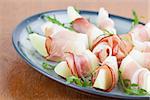 Prosciutto and honeydew melon appetizers with arugula