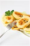 fried calamari and lemon slice on white tray