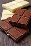 pieces of white and milk chocolate on brown wooden table