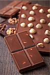 pieces of milk chocolate with nuts on brown wooden table
