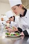 Chef preparing a salad in culinary class in kitchen