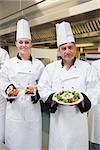 Chef's presenting their salads in the kitchen