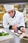 Chef putting mint with chocolate cake in the kitchen