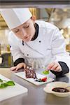 Female chef putting mint with chocolate cake in the kitchen