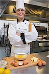 Pastry chef with rolling pin making dough in the kitchen