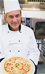 Smiling chef showing mushroom pizza
