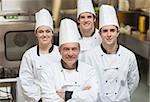 Smiling team of Chef's standing in kitchen