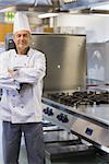 Chef smiling while standing at stove in the kitchen