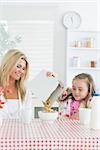 Mother and daughter having cereal at breakfast