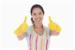 Smiling woman in rubber gloves and apron giving thumbs up