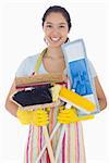 Woman in apron and rubber gloves holding mops and brushes
