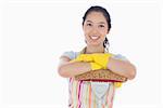 Happy woman wearing gloves and apron leaning on mop