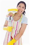 Distressed woman holding cleaing tools wearing an apron