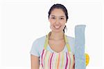 Smiling woman holding dust mop and wearing apron