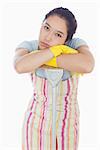 Frowning woman leaning in mop wearing apron and rubber gloves