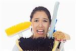 Very stressed young woman with cleaning tools