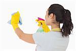 Brunetter woman spraying and wiping in rubber gloves