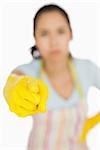 Woman in apron and gloves pointing accusingly ahead