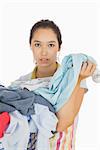 Tired woman holding dirty laundry from the basket