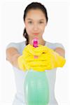 Woman pointing a spray bottle on white background