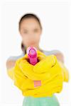 Confident woman pointing a spray bottle at the camera on a white background