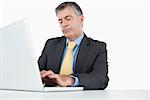 Concentrated man typing on his laptop at his desk