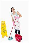 Woman cleaning near a caution wet floor sign