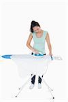 Brunetter ironing white shirt on ironing board