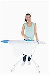 Happy woman doing the ironing on ironing board