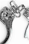 Silver handcuffs lying against white background