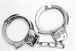 Silver handcuffs against white background