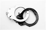 Black and silver handcuffs against white background