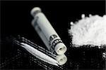 Pile of illegal white drug substance beside rolled up note and a line