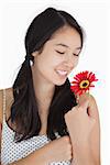 Smiling woman in pigtails holding red flower