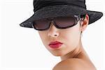 Woman wearing sun glasses and hat against white background