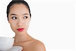 Woman holding a cup of coffee looking away on white background