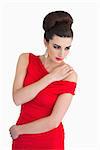 Glamorous woman in red dress holding her shoulder