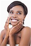 Happy woman putting on face cream on white background