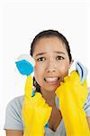 Stressed woman holding scrubbing brush and rag wearing rubber gloves