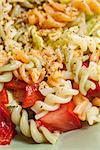 Colorful salad with pasta and variety of vegetables.