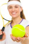 Closeup on tennis ball in hand of female tennis player