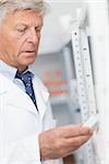 Pharmacist looking at pills in a shelf in a hospital