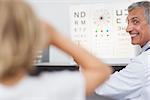 Joyful doctor doing an eye test on a patient in a hospital examination room