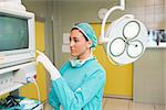 Female surgeon standing next to a monitor in a surgery room