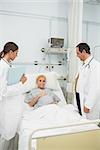 Doctors standing next to a patient in a hospital bed