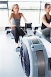 Rowing machine being used by woman in gym