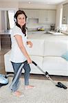 Woman cleaning the house while wearing headphones